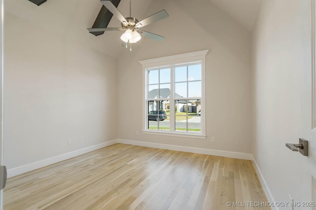 unfurnished room with light wood-style floors, baseboards, ceiling fan, and vaulted ceiling