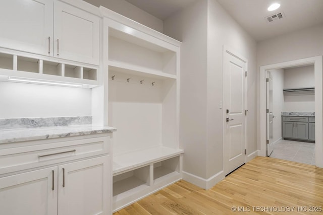 mudroom with baseboards, light wood finished floors, and visible vents