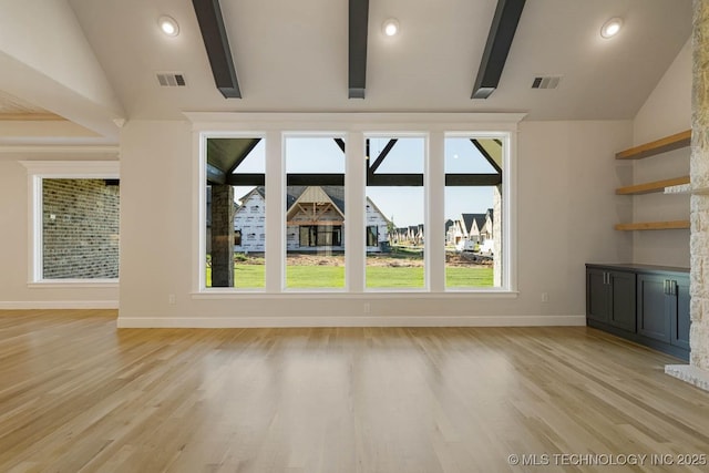 unfurnished living room featuring baseboards, visible vents, and lofted ceiling with beams