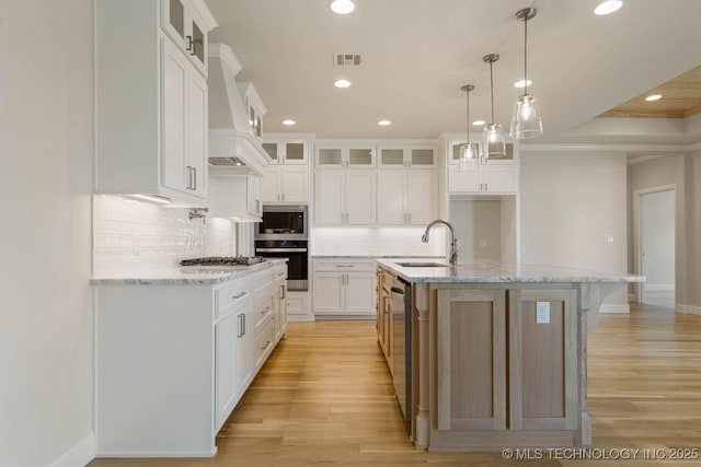 kitchen featuring decorative backsplash, appliances with stainless steel finishes, a sink, custom range hood, and recessed lighting