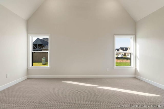 unfurnished room featuring light colored carpet, baseboards, and high vaulted ceiling