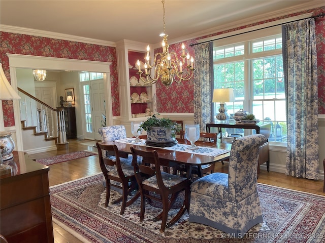 5730 Rolling Oaks Dr, Muskogee, OK 74401 - dining space featuring a notable chandelier, wallpapered walls, wood finished floors, ornamental molding, and stairway
