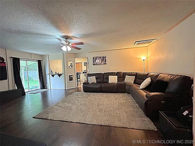 living area with visible vents, a textured ceiling, ceiling fan, and wood finished floors