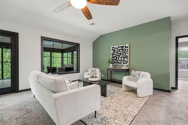 living room featuring ceiling fan, visible vents, vaulted ceiling, baseboards, and carpet