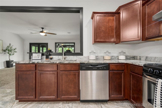kitchen featuring a peninsula, ceiling fan, light stone counters, a sink, and stainless steel appliances