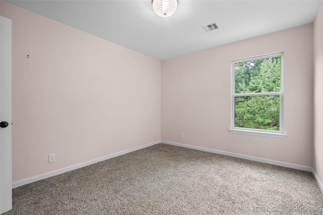 empty room featuring carpet floors, baseboards, and visible vents