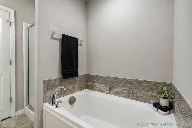bathroom with a stall shower and a bath