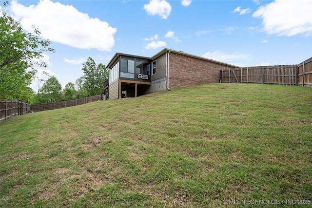 view of yard featuring a fenced backyard and a sunroom