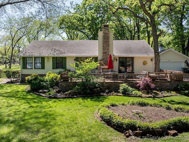 ranch-style house with a front lawn, a deck, roof with shingles, a chimney, and brick siding