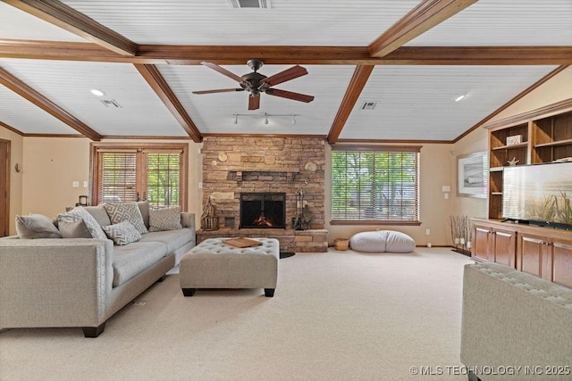 living area featuring ceiling fan, carpet flooring, a stone fireplace, and visible vents