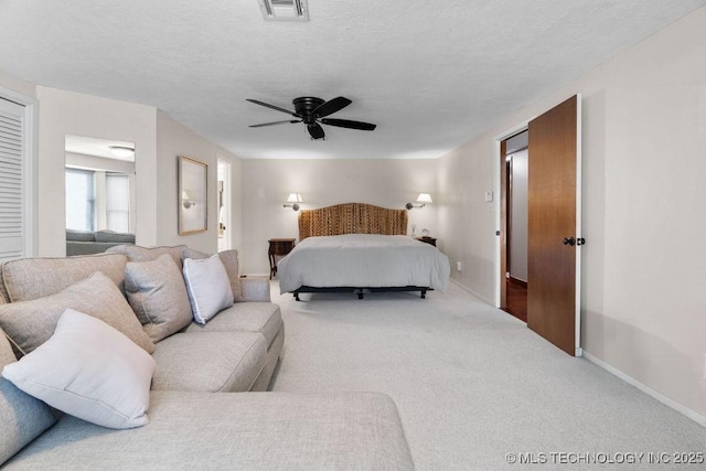 carpeted bedroom with visible vents, a textured ceiling, baseboards, and ceiling fan
