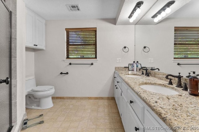bathroom featuring a sink, toilet, and a healthy amount of sunlight