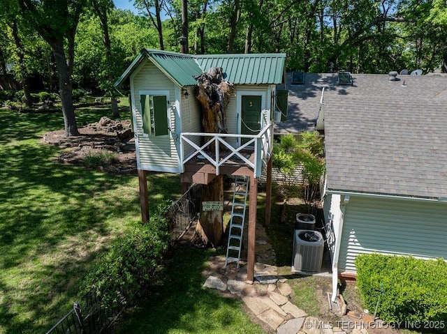view of front of house featuring stairs, roof with shingles, central air condition unit, and a front yard