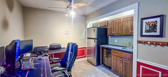 office space featuring light colored carpet, a sink, beverage cooler, indoor wet bar, and a ceiling fan