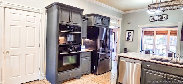 kitchen featuring crown molding, light stone countertops, appliances with stainless steel finishes, and a sink