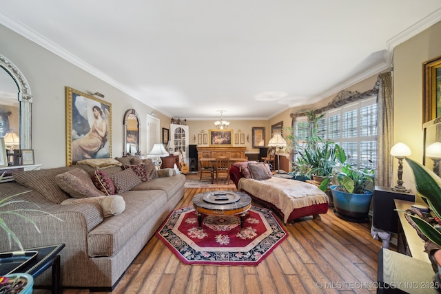 living room with ornamental molding, wood finished floors, and a notable chandelier