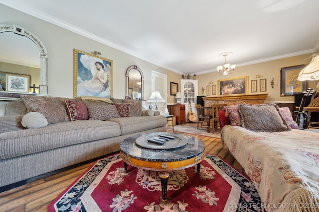 living area featuring an inviting chandelier, ornamental molding, and wood finished floors