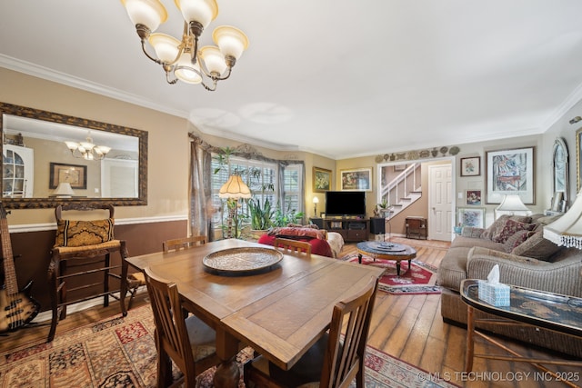 dining area with stairway, ornamental molding, hardwood / wood-style flooring, and a notable chandelier