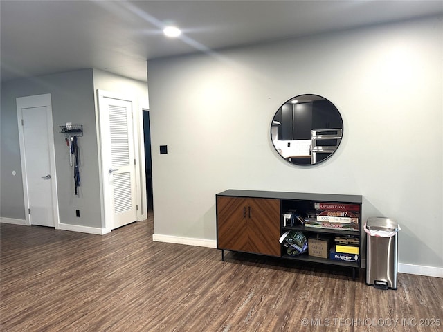 interior space featuring baseboards and wood finished floors