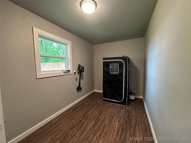 interior space featuring baseboards and dark wood-style flooring
