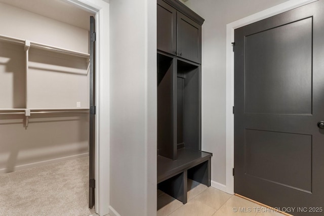 mudroom featuring baseboards and light colored carpet