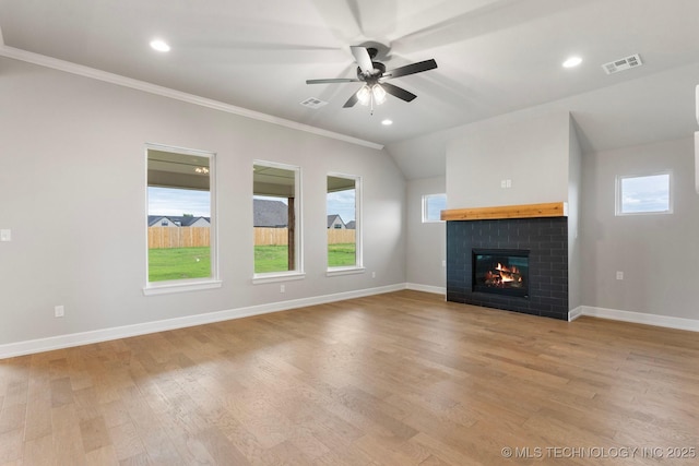 unfurnished living room with light wood finished floors, a brick fireplace, a ceiling fan, visible vents, and ornamental molding