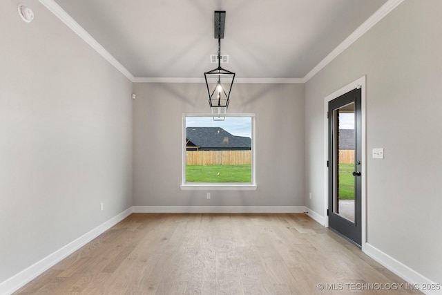 unfurnished dining area featuring light wood-style floors, baseboards, ornamental molding, and visible vents