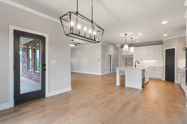 kitchen with crown molding, a sink, dishwasher, and open floor plan