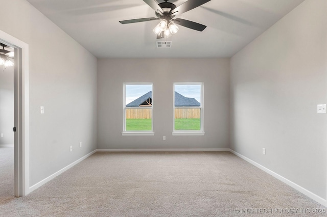 spare room featuring carpet, a ceiling fan, and visible vents