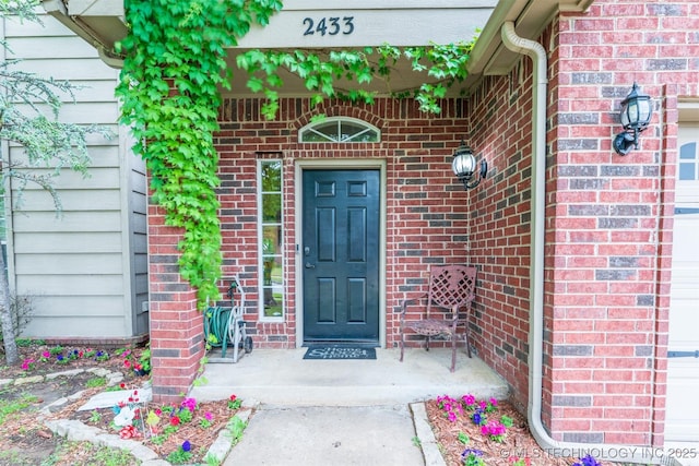view of exterior entry featuring brick siding