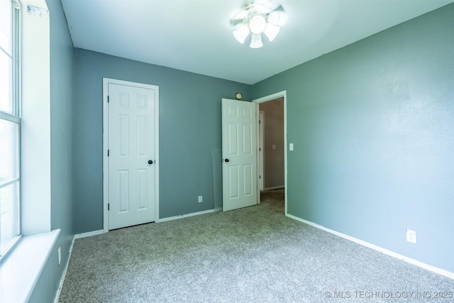 unfurnished bedroom with carpet floors and baseboards