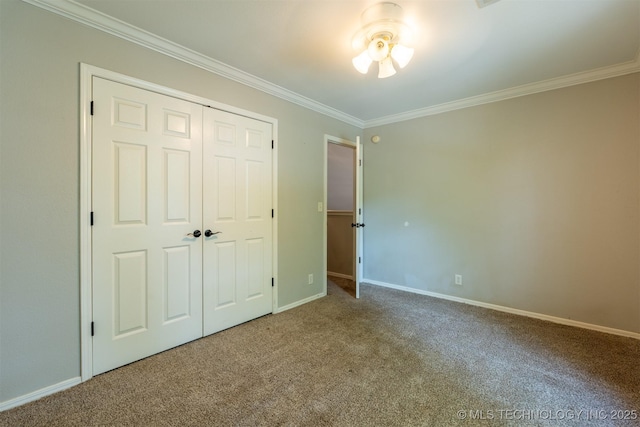 unfurnished bedroom featuring baseboards, ornamental molding, carpet, and a closet