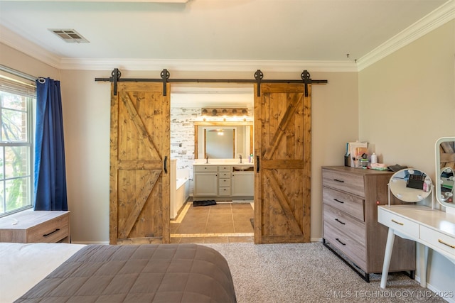 bedroom with crown molding, visible vents, a barn door, and connected bathroom