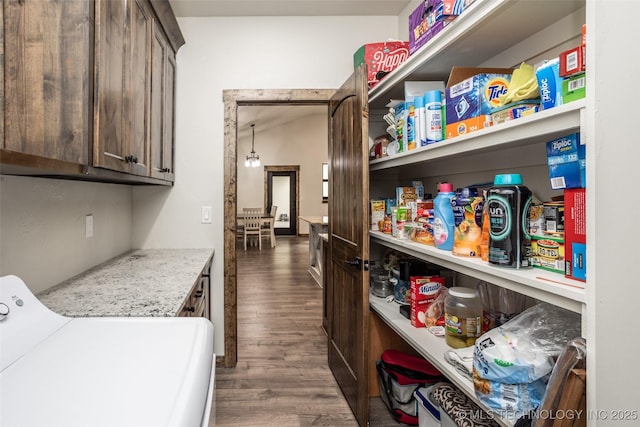laundry room with dark wood-type flooring and cabinet space