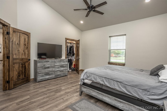 bedroom with recessed lighting, wood finished floors, a spacious closet, and high vaulted ceiling