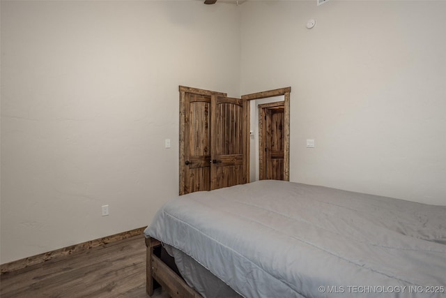 bedroom featuring a ceiling fan, baseboards, and wood finished floors