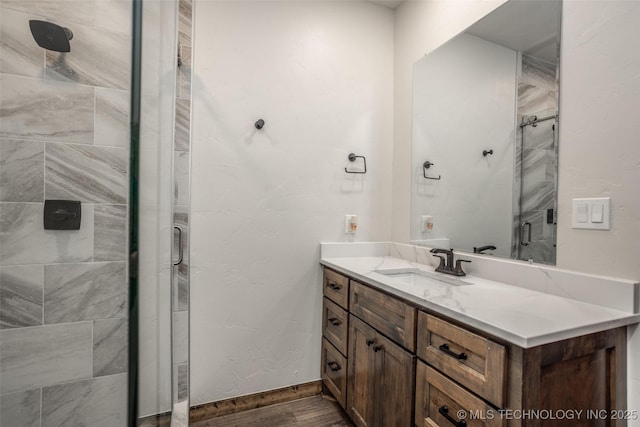 full bathroom featuring vanity, a shower stall, and wood finished floors