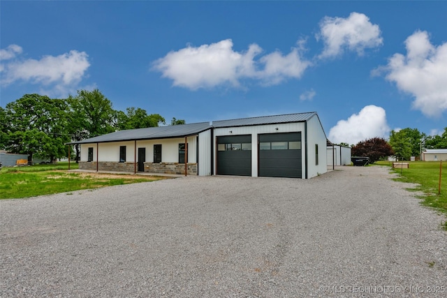 view of front of home with driveway, metal roof, and a garage