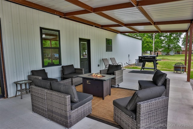view of patio / terrace with grilling area, a deck, and an outdoor living space with a fire pit