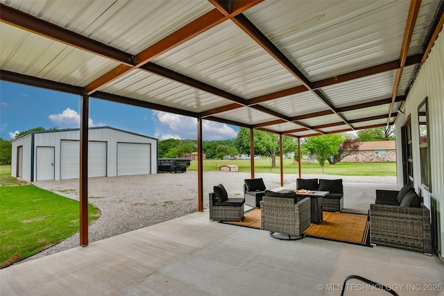 view of patio with a garage, an outbuilding, and an outdoor hangout area