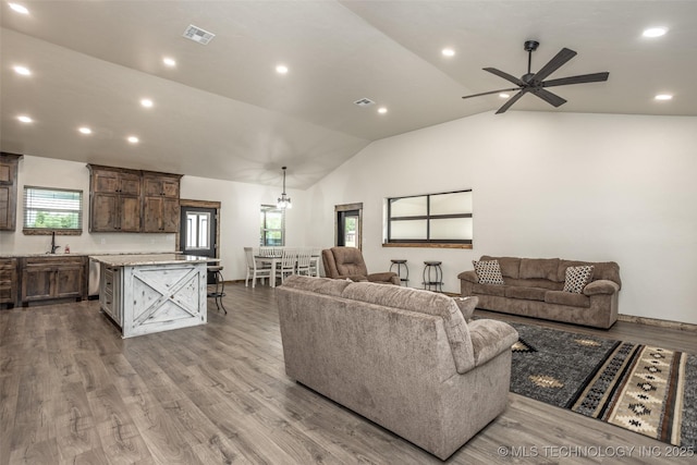 living room with ceiling fan, visible vents, wood finished floors, lofted ceiling, and recessed lighting
