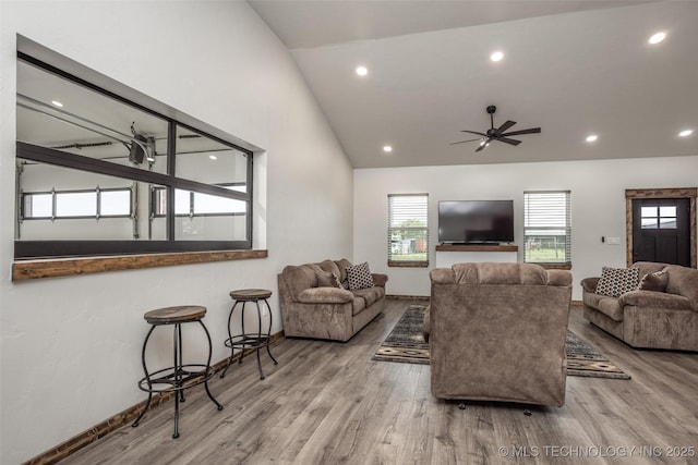 living room with ceiling fan, plenty of natural light, wood finished floors, and lofted ceiling