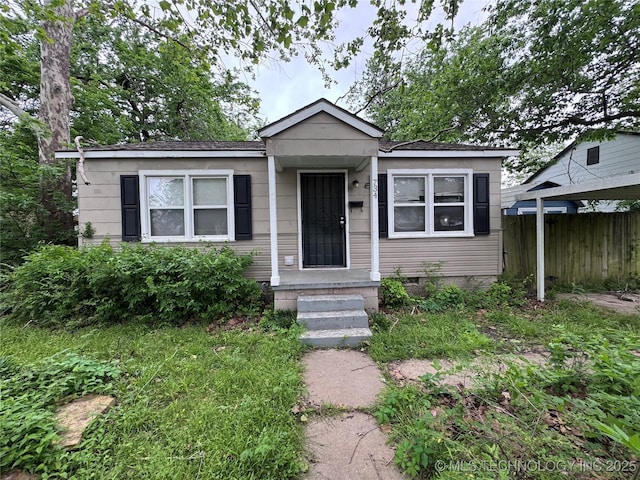 bungalow-style house with fence and crawl space