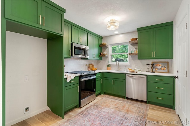 kitchen featuring stainless steel appliances, open shelves, decorative backsplash, and green cabinets