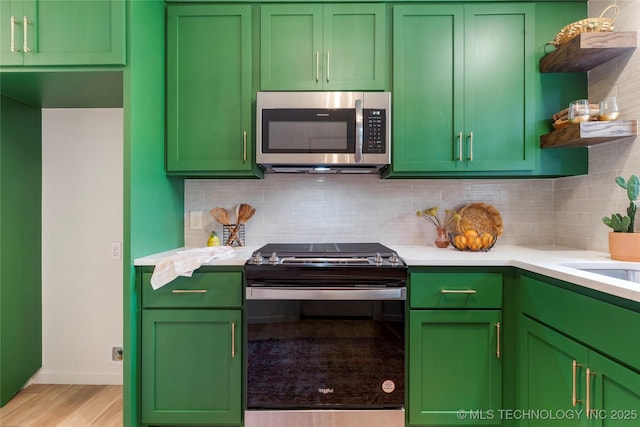 kitchen featuring open shelves, decorative backsplash, gas range, light countertops, and stainless steel microwave