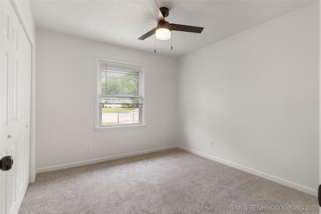 carpeted empty room featuring baseboards and ceiling fan