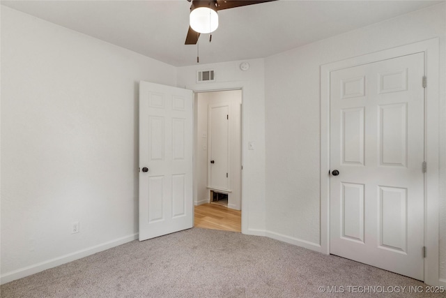 unfurnished bedroom with carpet floors, baseboards, a ceiling fan, and visible vents