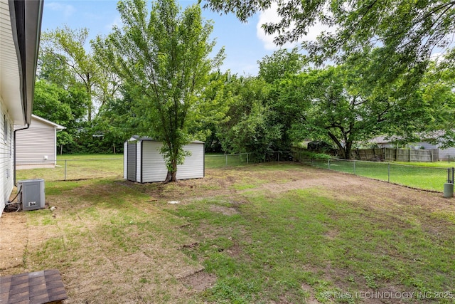 view of yard featuring a fenced backyard, a storage unit, and an outdoor structure