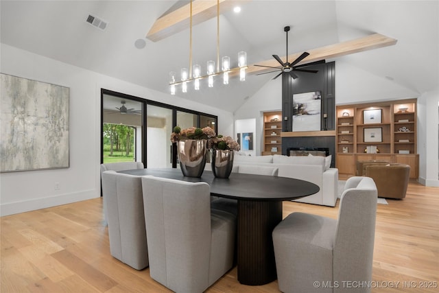 dining space with high vaulted ceiling, ceiling fan, a large fireplace, and visible vents