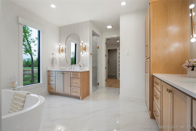 bathroom featuring a freestanding bath, vanity, baseboards, marble finish floor, and recessed lighting